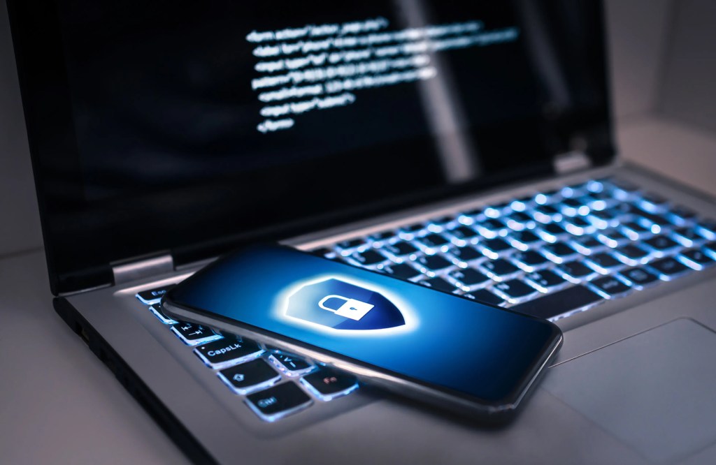 Smartphone placed on a laptop displaying a padlock icon